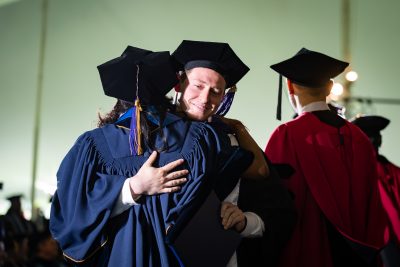 Graduate hugs professor after being robed