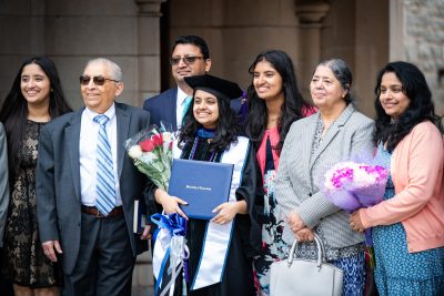 Graduate with diploma poses with family